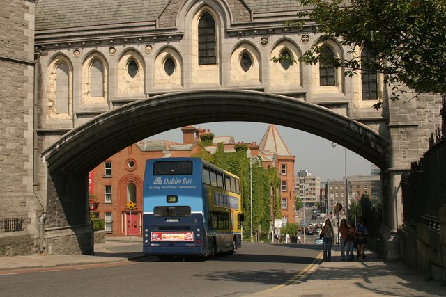 Автобус Dublin Bus проезжает под каменной аркой собора Крайст-черч в Дублине.