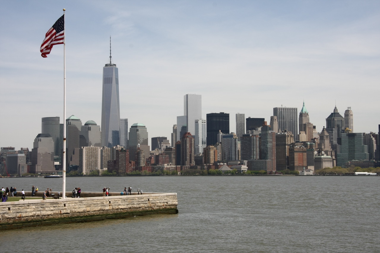 Вид на небоскреб One World Trade Center и флаг США в Нью-Йорке