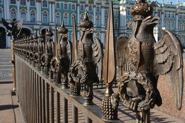 Бронзовая ограда с двуглавыми орлами на фоне Государственного Эрмитажа в Санкт-Петербурге
