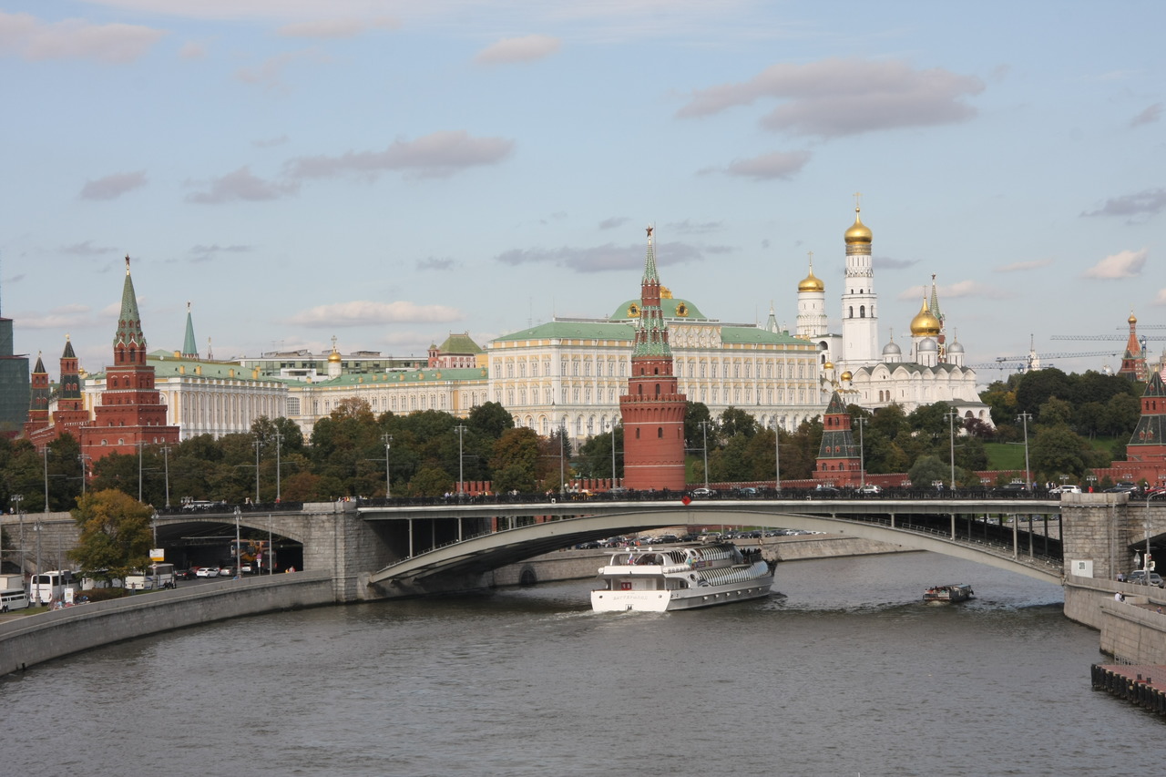 Вид на Большой Каменный мост и Московский Кремль в Москве с теплоходом на реке.