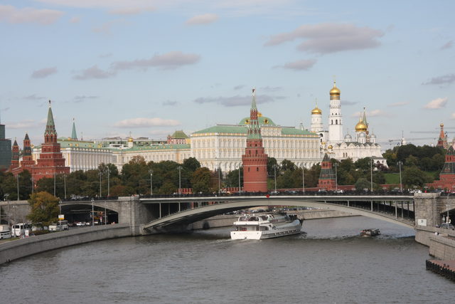 Вид на Большой Каменный мост и Московский Кремль в Москве с теплоходом на реке.