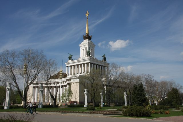 Вид на Центральный павильон ВДНХ в Москве с золотым шпилем и колоннадой.