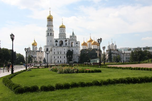 Вид на архитектурный ансамбль Московского Кремля с Ивановской и Соборной площадей на фоне голубого неба.