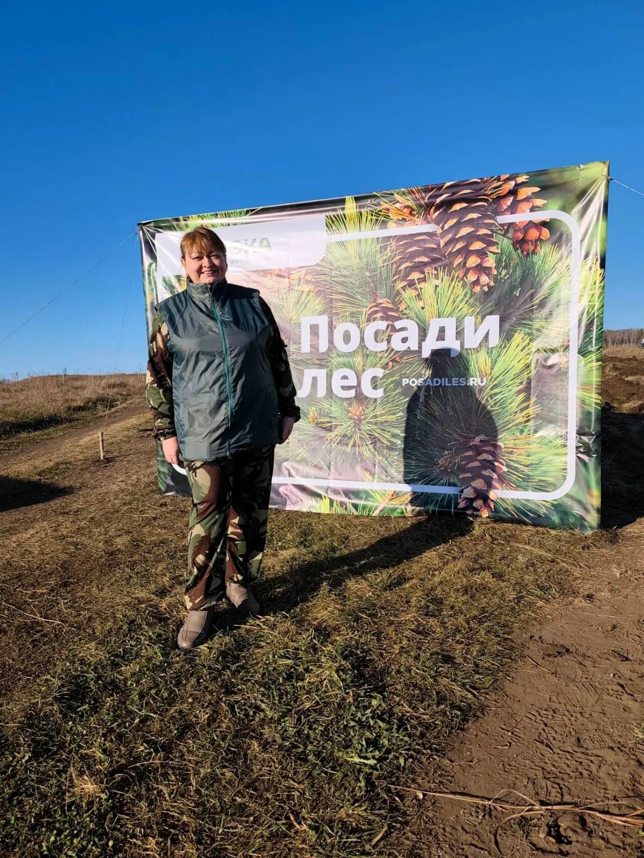 Участница акции возле баннера Посади лес